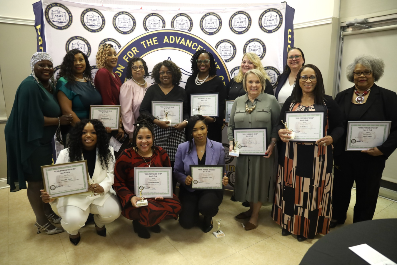 A group of award winners smile for a group photo
