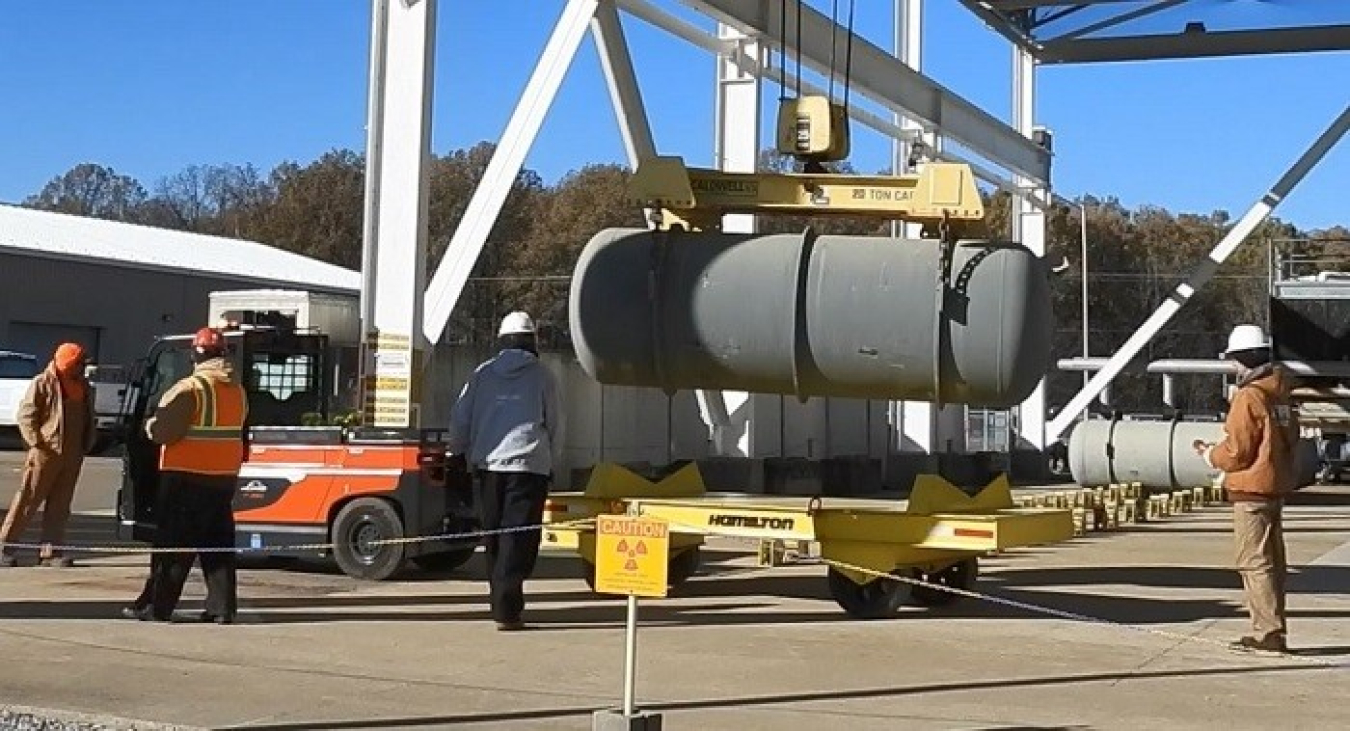 Workers use tow motors to offload a cylinder at the Paducah Site depleted uranium hexafluoride plant.