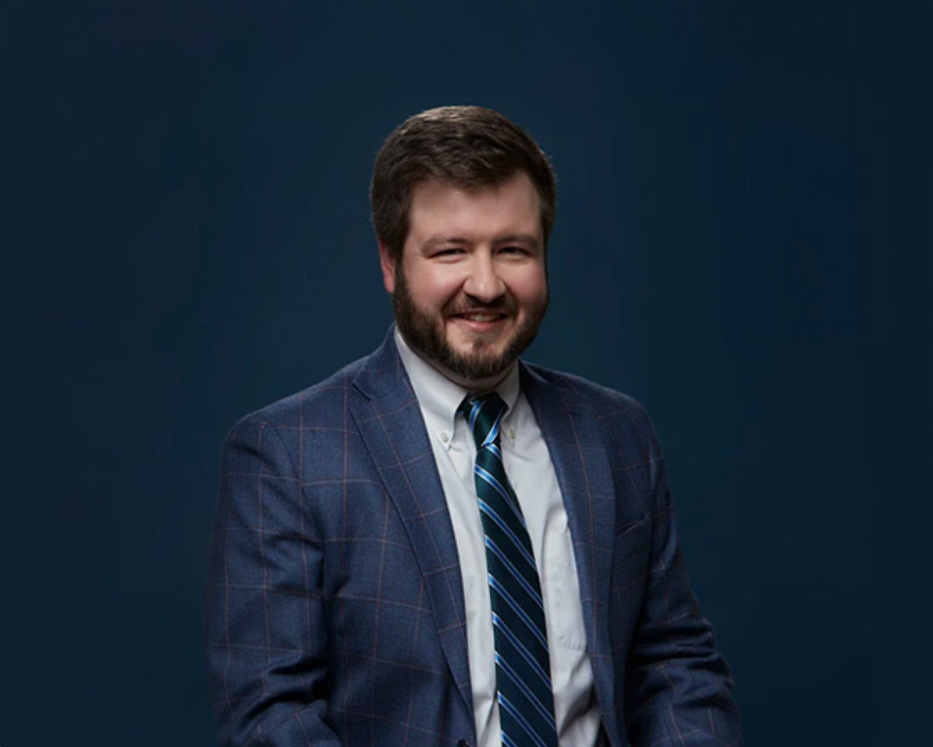 Matt Gurr posing for a portrait wearing a suit and tie.