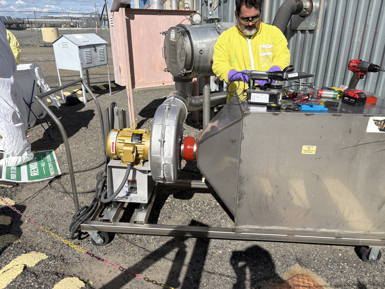 A technician working on a machine outside a building