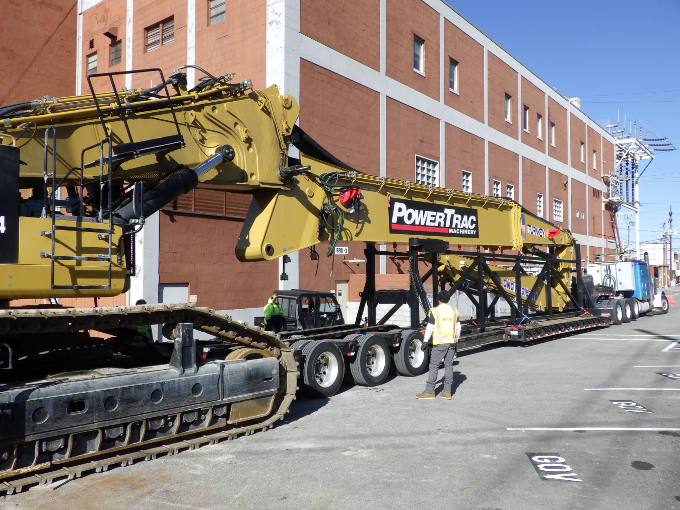Yellow specialized equipment machines parked outside a large building