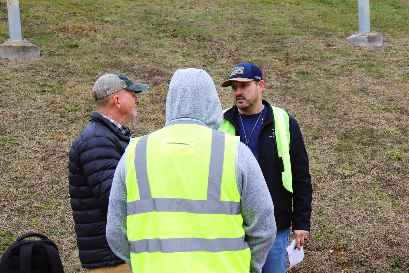 Three employees standing outside at the Oak Ridge site having a conversation