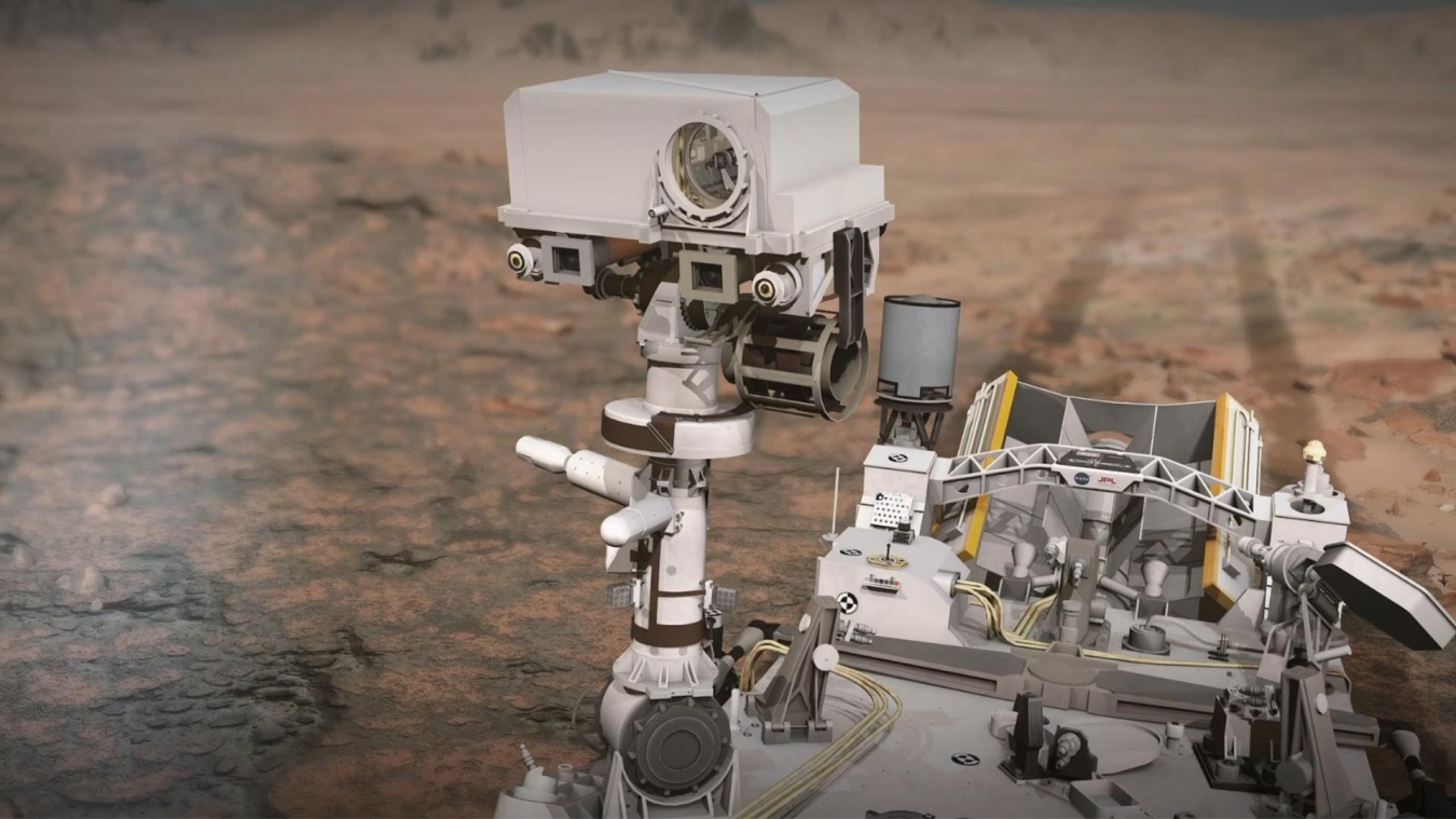 An artist's rendering of the Mars Perseverance rover's SuperCam as the vehicle trundles about Mars, with tread marks trailing it on the surface. SuperCam is square-shaped, about as big as a football and has a circular lens on one side of it.