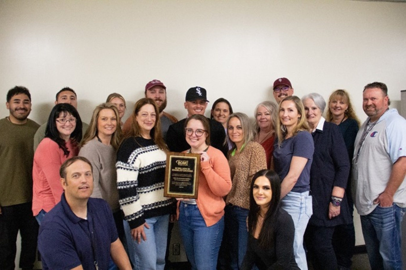 Idaho Environmental Coalition’s procurement team holds a plaque commending the company for contributing nearly $3.7 million toward the $2 billion Supply Chain Management Center-enabled savings milestone.