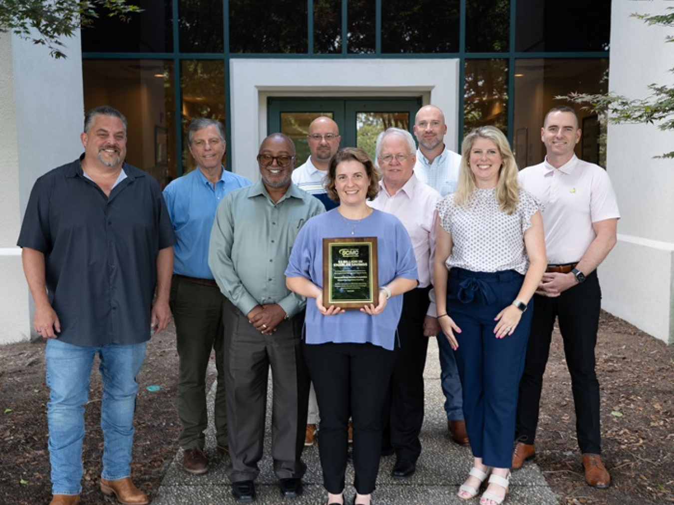Savannah River Mission Completion team holds a plaque recognizing the company for contributing $38.3 million of a $2 billion total cost savings over three years. 