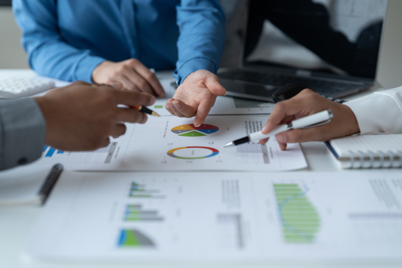 A group of people look over risk assessment documents that show graphs and data.