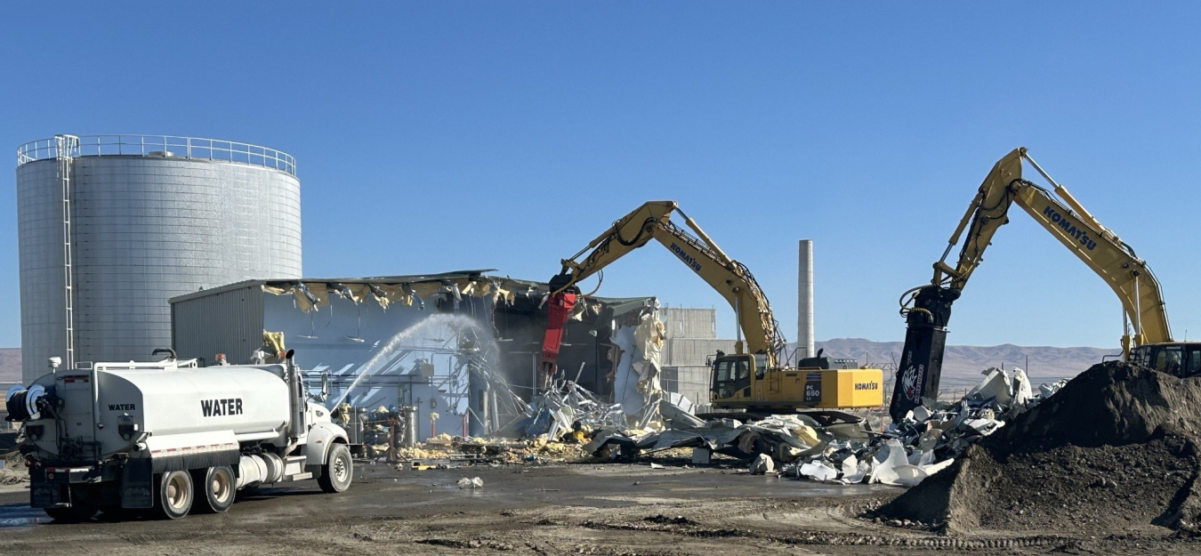 A demolition site with multiple construction vehicles working