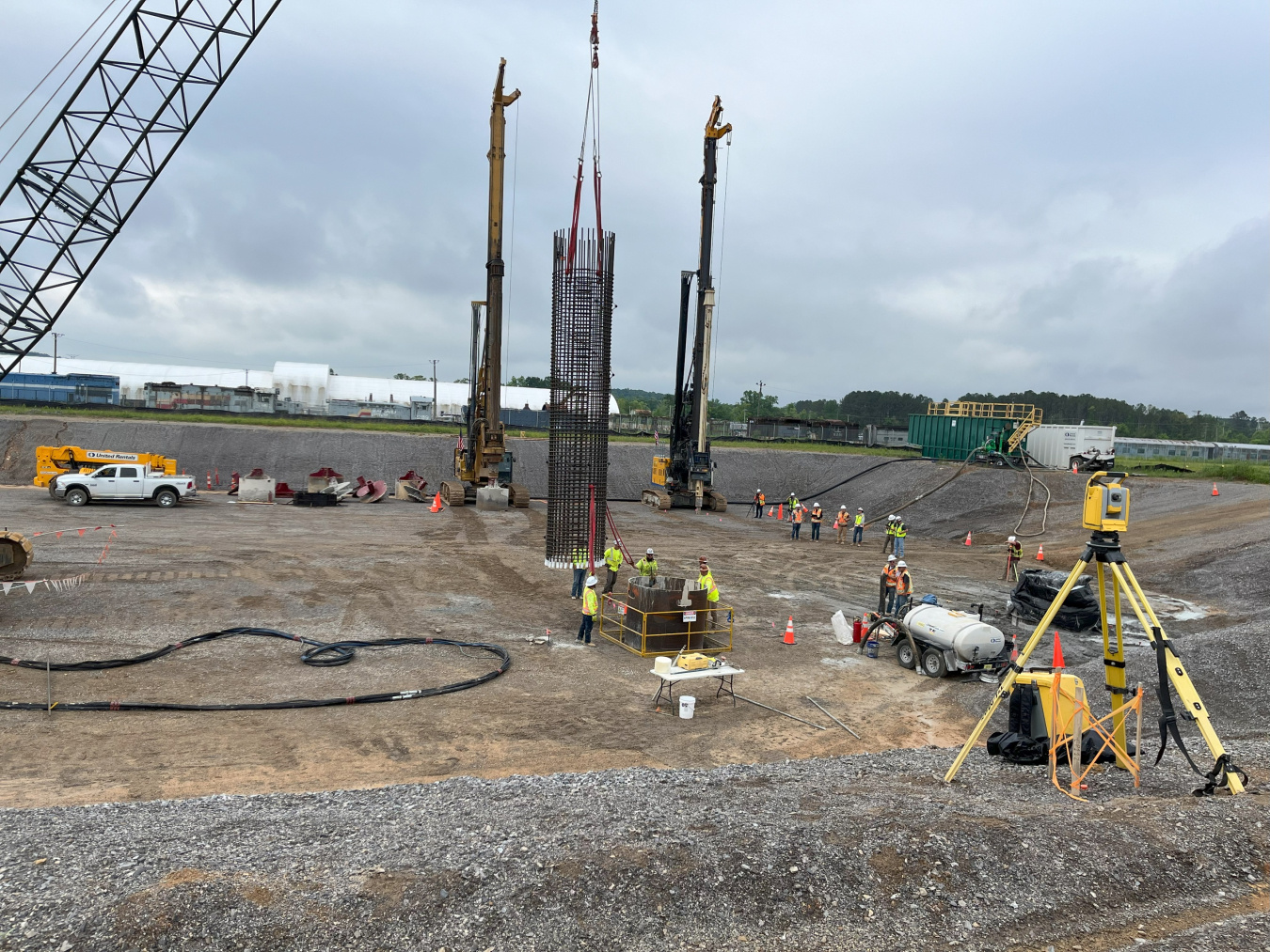 A construction site, workers build the foundation of a new facility building