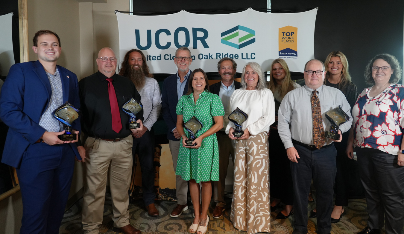 A group picture at an awards ceremony with people smiling while holding awards
