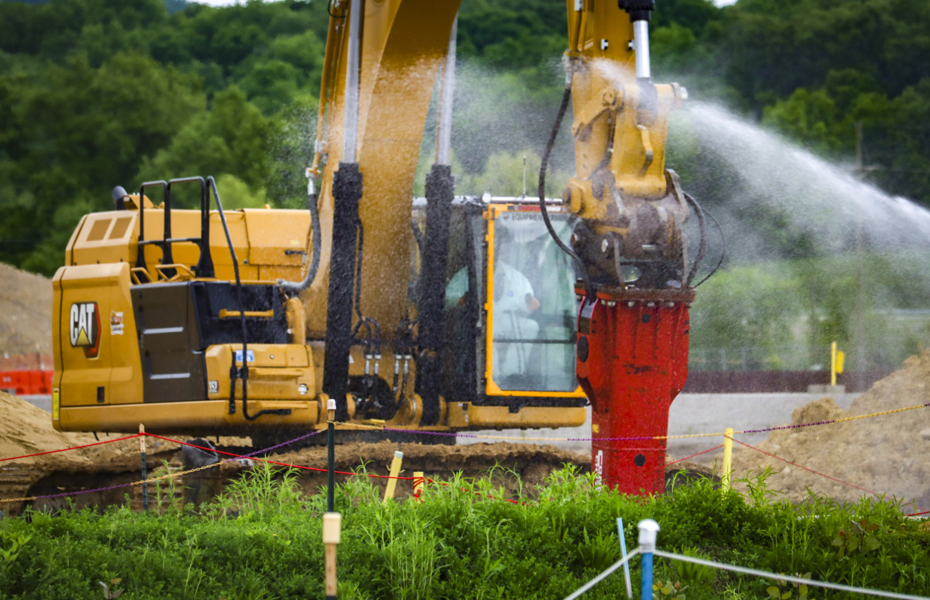 A work vehicle spraying water while conducting a demolition