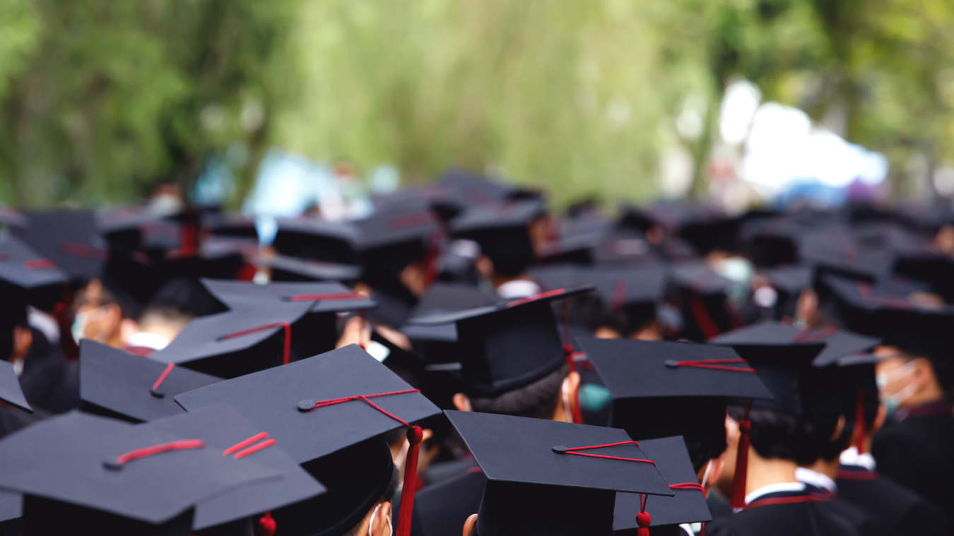 A photo showing a large group of college students wearing a cap and gown. 
