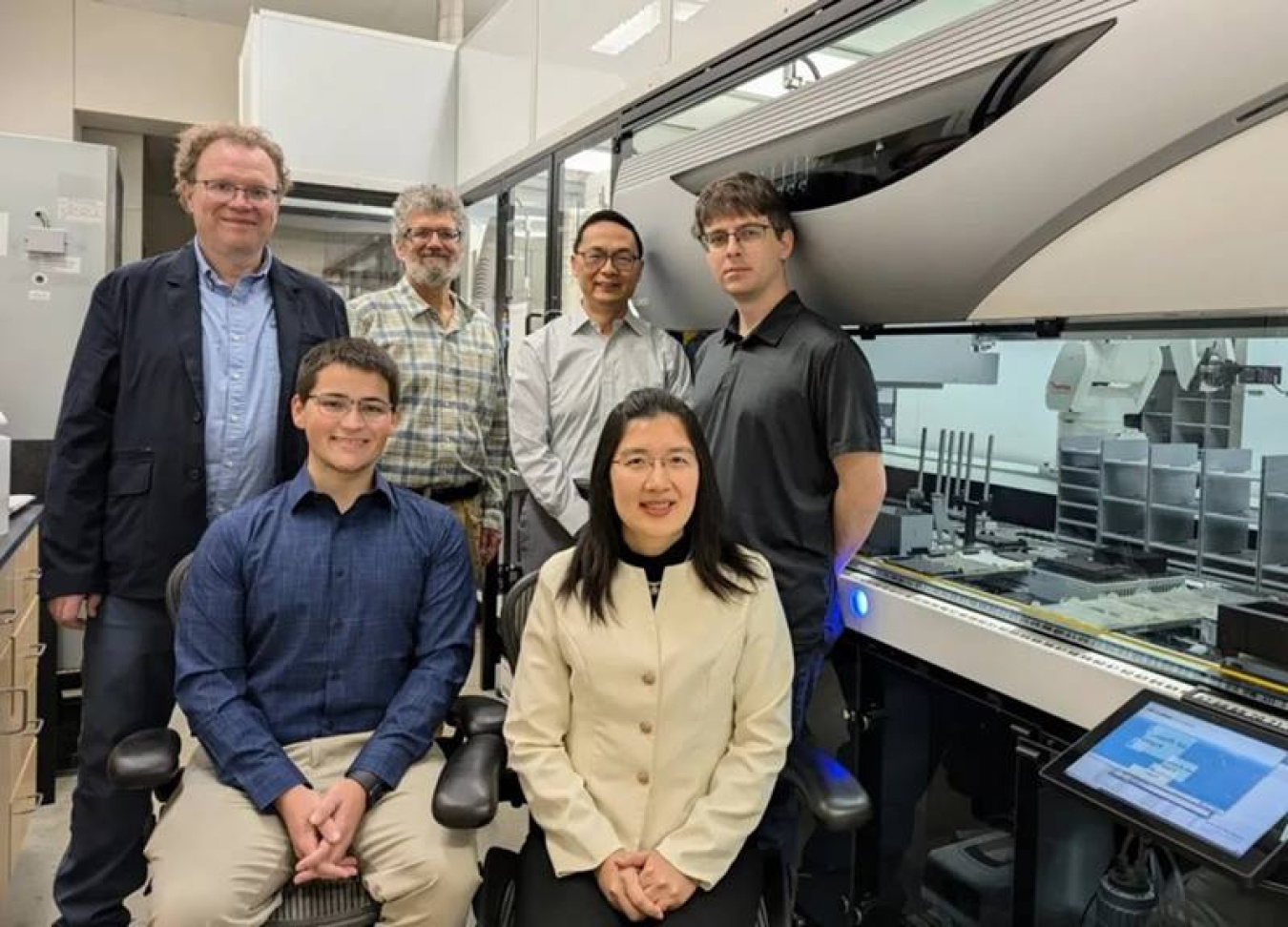 The CABBI team in the iBioFAB biofoundry at the Carl R. Woese Institute for Genomic Biology (IGB). Front row, researchers Seth Croslow and Jia Dong. Back row, from L: PIs Mathew Hudson, Jonathan Sweedler, Huimin Zhao, and Biofoundry Manager Stephan Lane