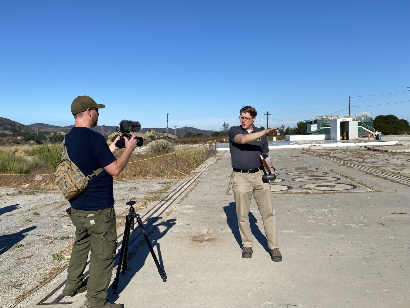 A man with a camera recording another man giving a tour of the ETEC site