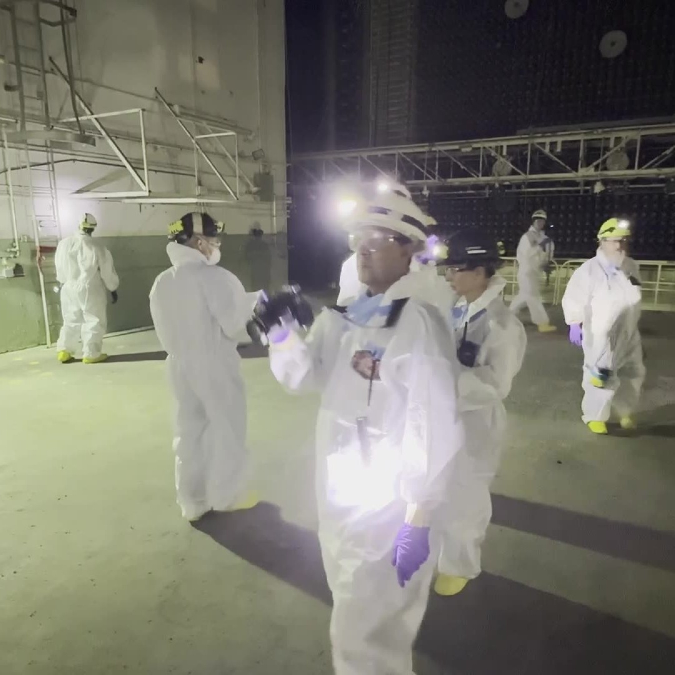 Employees in protective gear carrying out an inspection inside a facility building