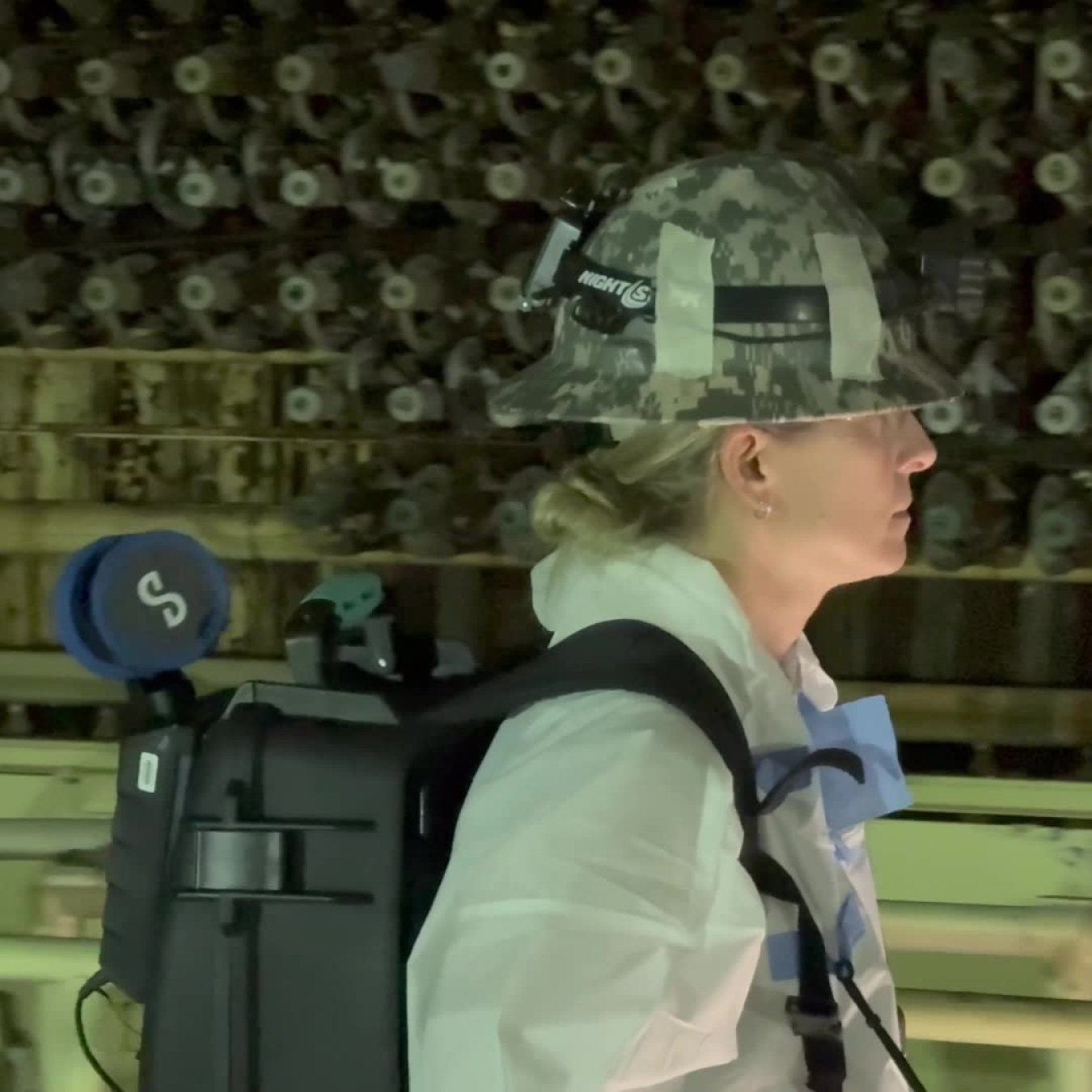 An employee wearing protective gear and a black Lidar backpack conducting an inspection
