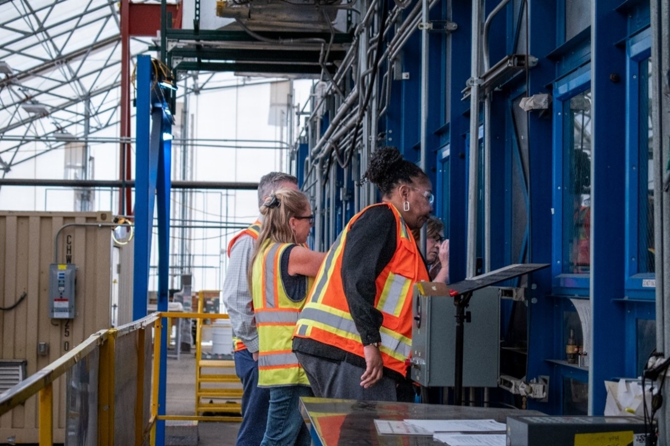 A group of individuals in safety vests touring a facility 