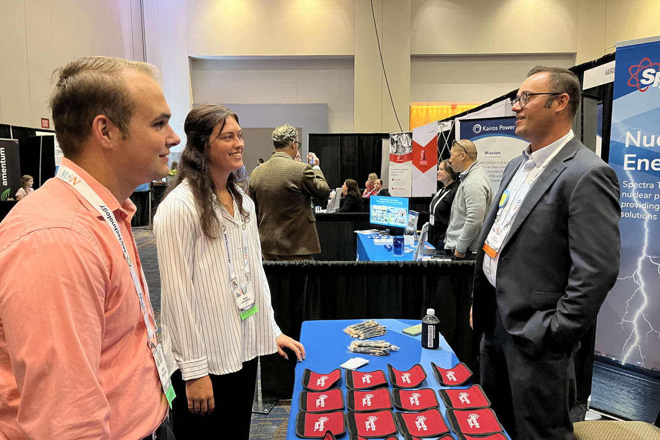 Two interns speaking to an employee at a Nuclear Opportunity Workshop