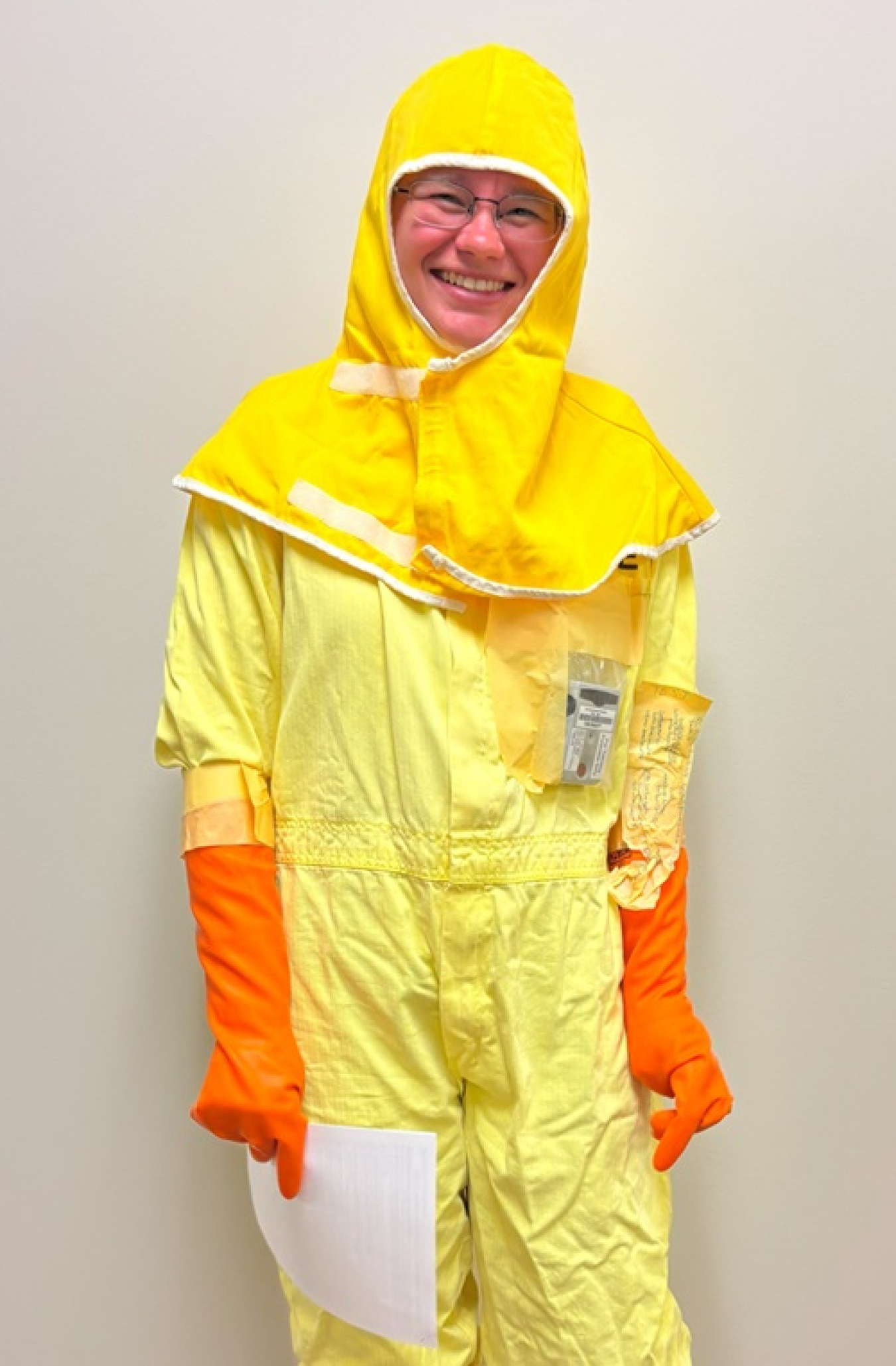 A woman in yellow protective gear and orange gloves