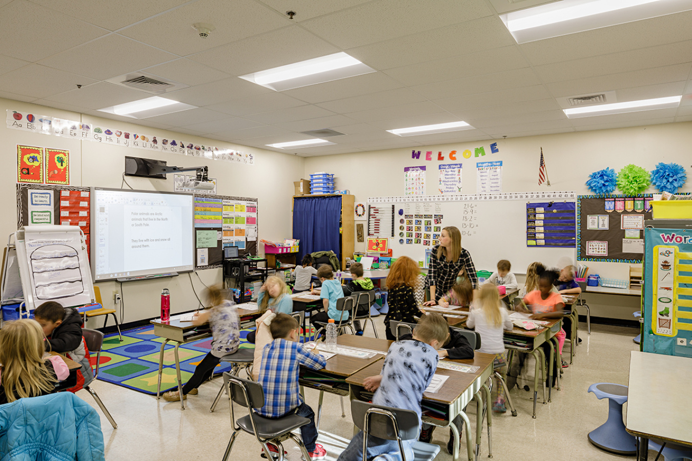 Students and a teacher working in a classroom.
