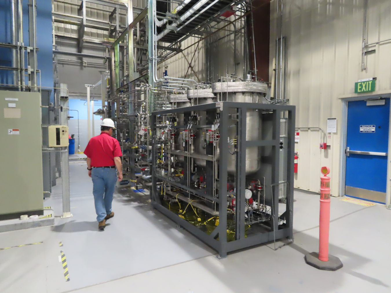 Am employee walking by a filtration system inside a facility at the Hanford Site