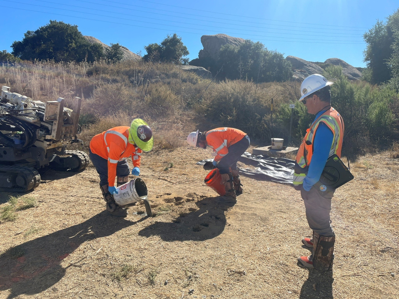 Workers conduct soil sampling