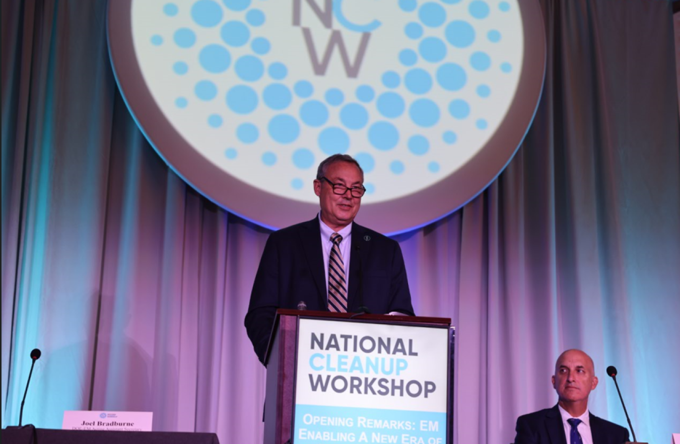A man standing behind a podium on a stage delivering a speech