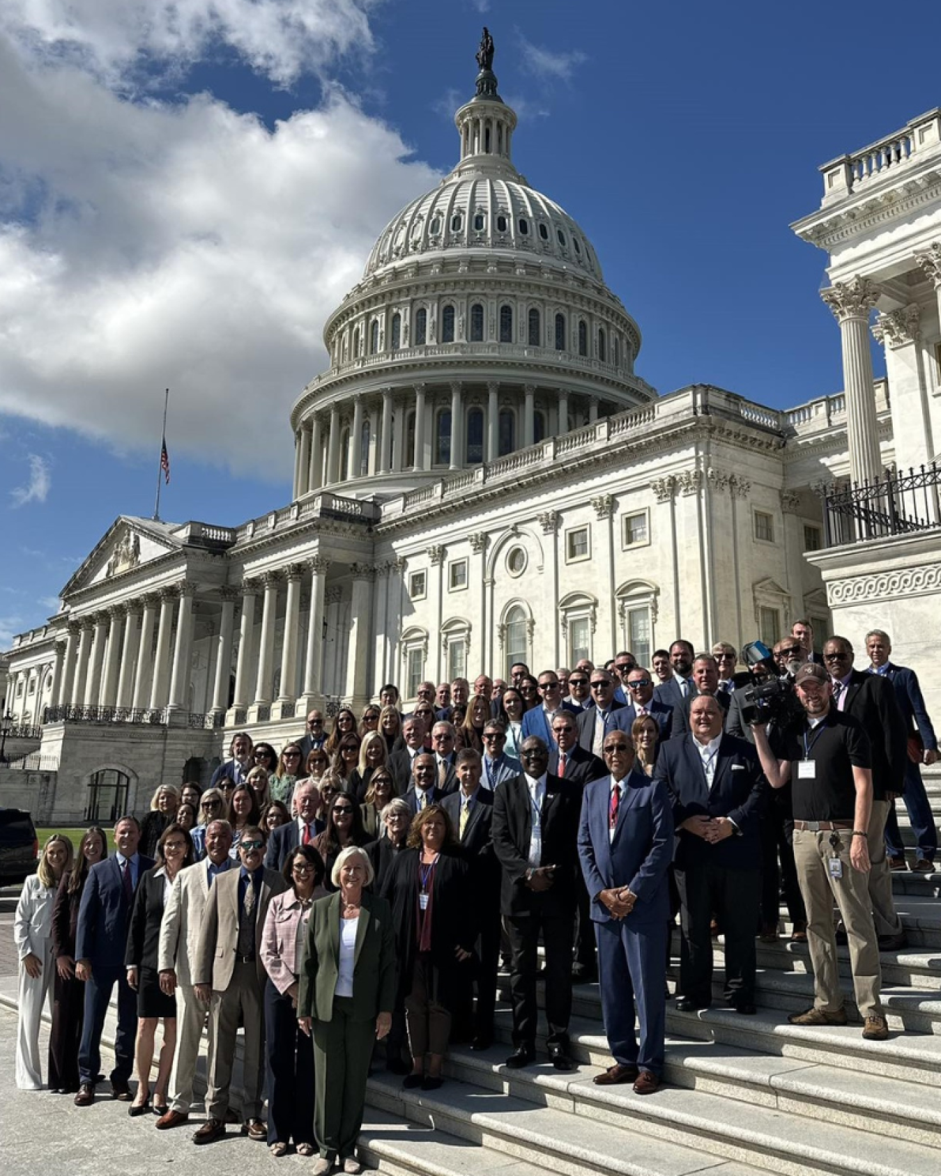 A large group of people posing for a photo on the steps of the U.S. Capitol Building