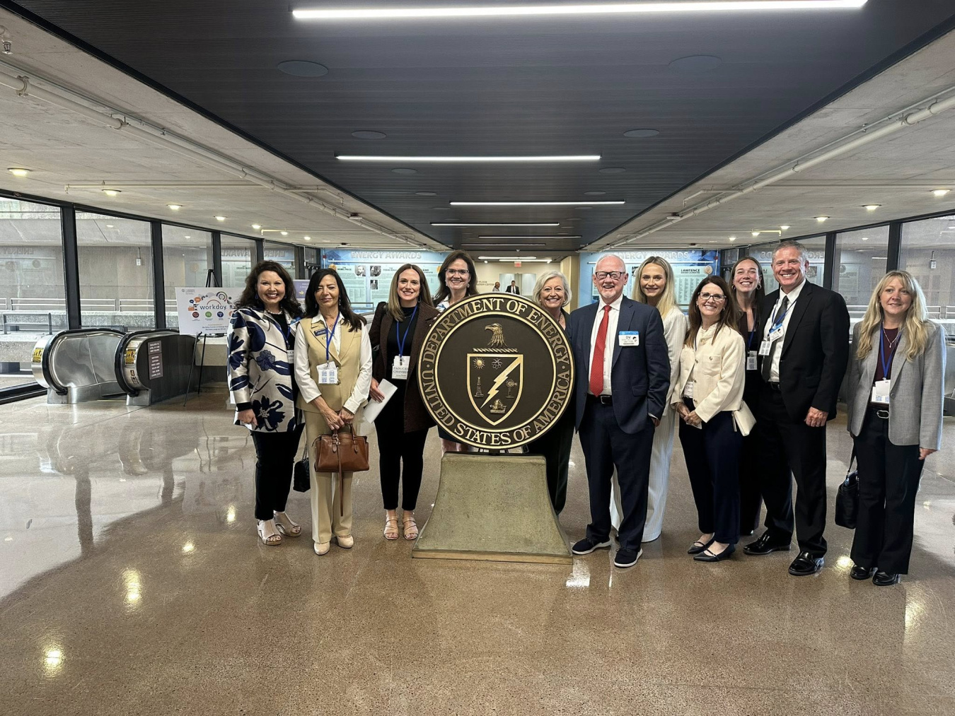 A group of individuals posing for a photo in the Department of Energy Headquarters lobby