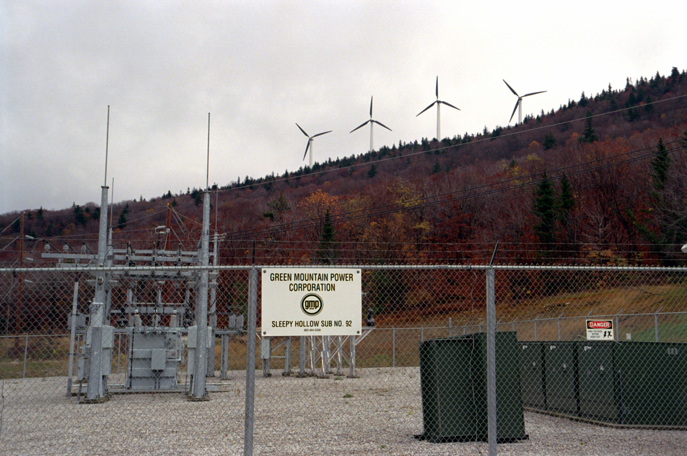 Wind turbines on a hill behind an electricity substation
