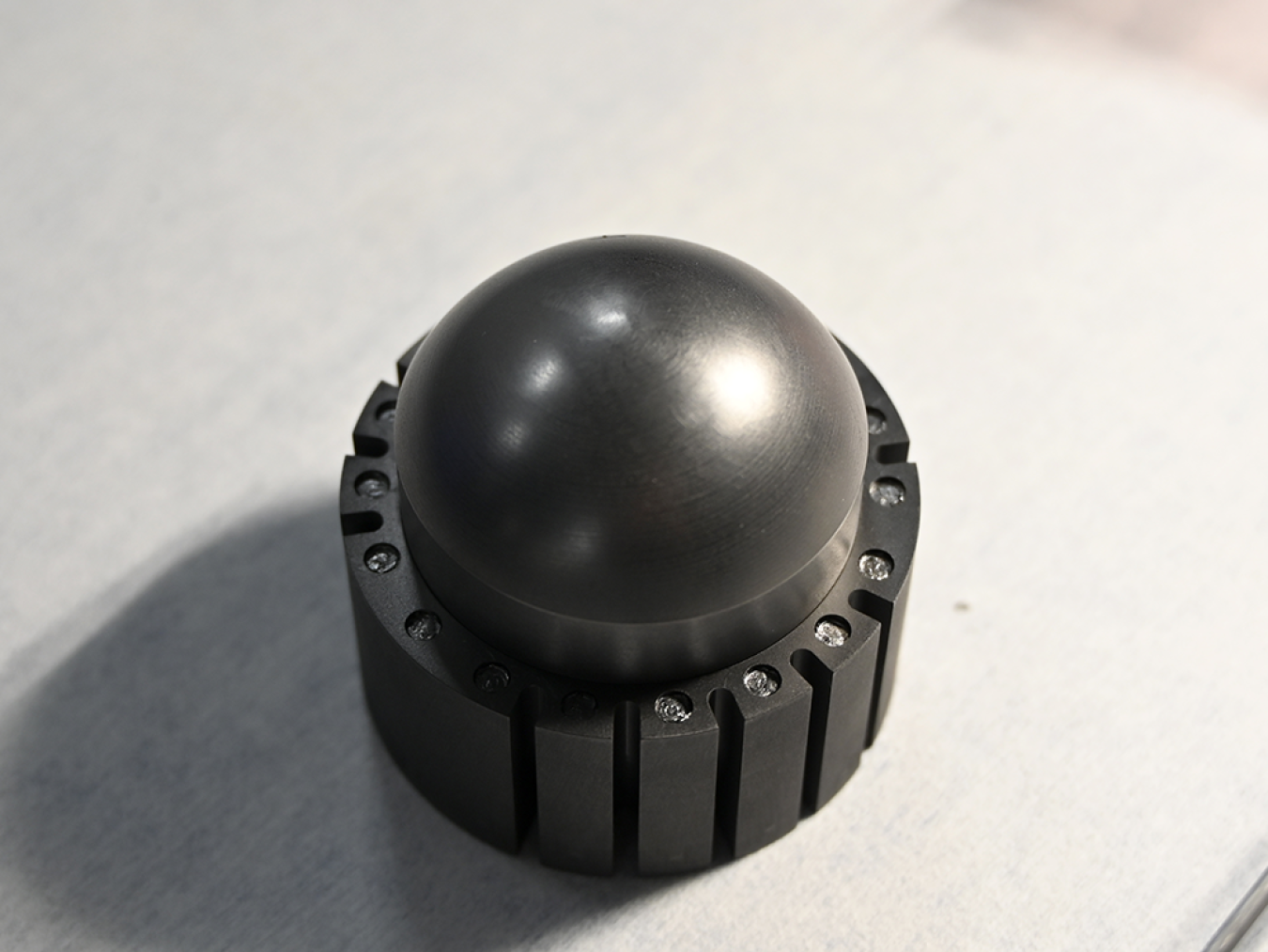 Black spherical fuel pebble on white table