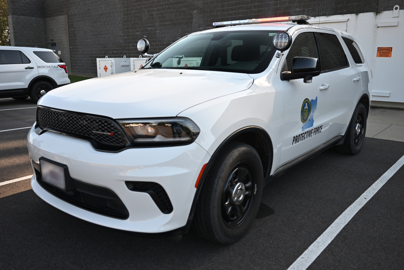 A white protective force patrol car with lights on the top and the PPPO logo on the driver's door