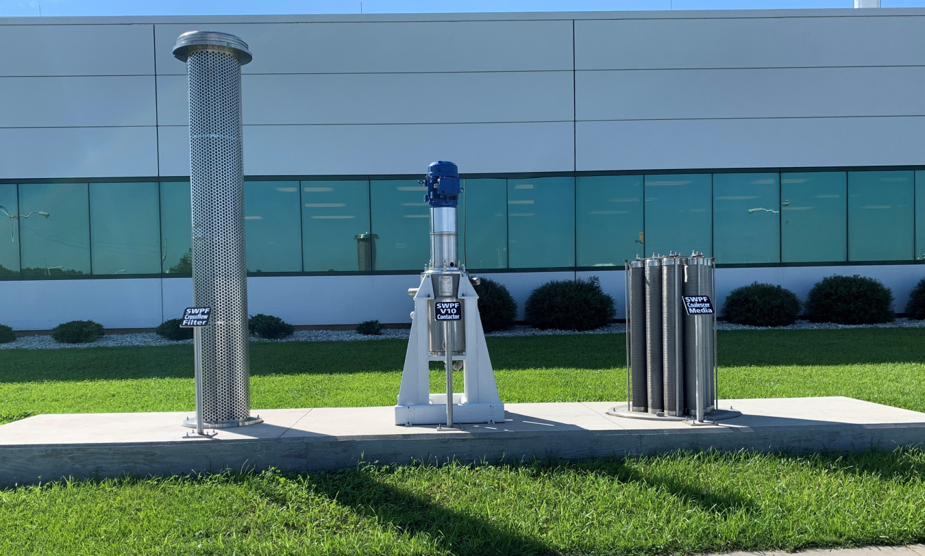 A display of a silver cross flow filter, a silver contactor and silver coalescer outside a building