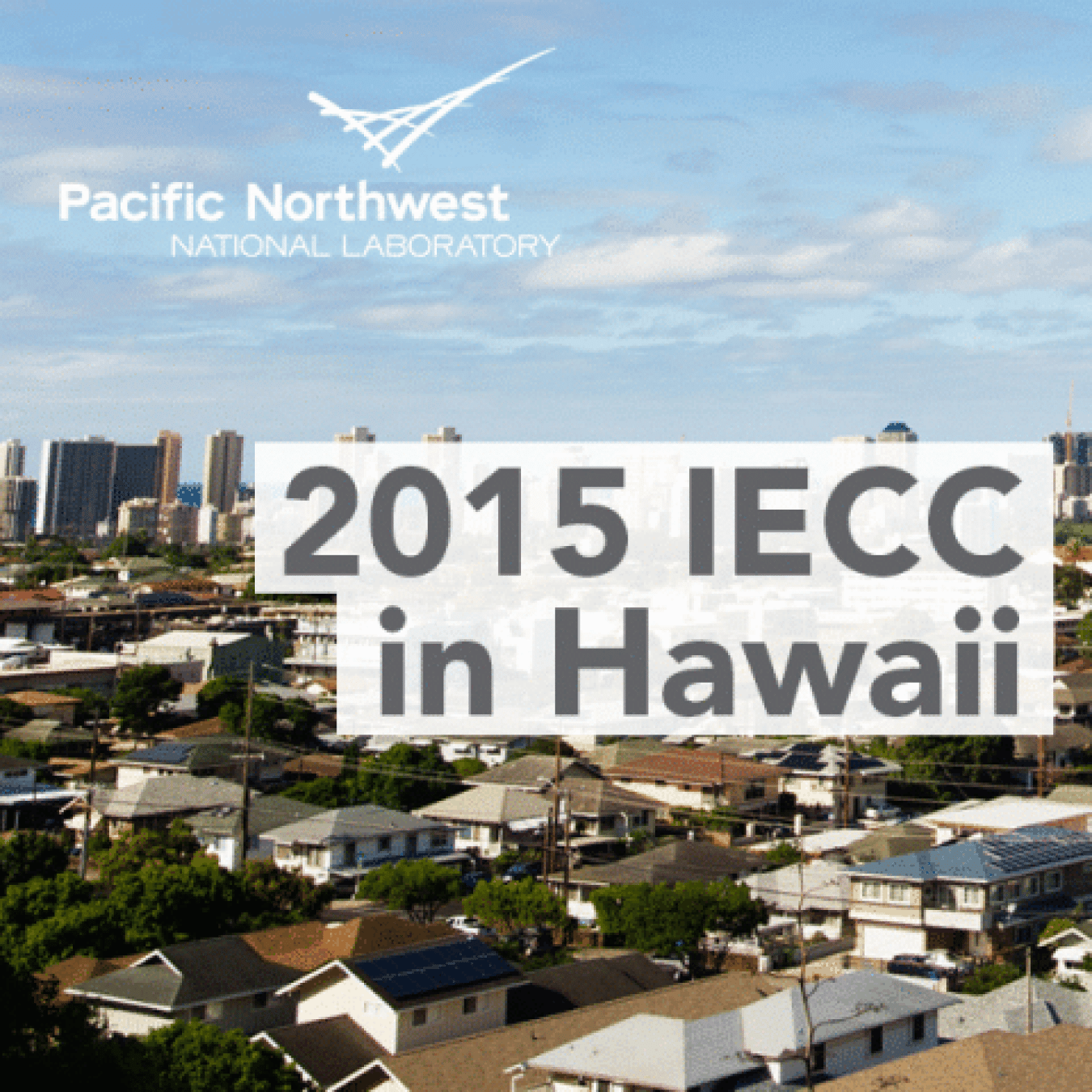 The words "2015 IECC in Hawaii" superimposed over a photo of a cluster of homes and buildings and the logo of Pacific Northwest National Lab on top of the sky above.