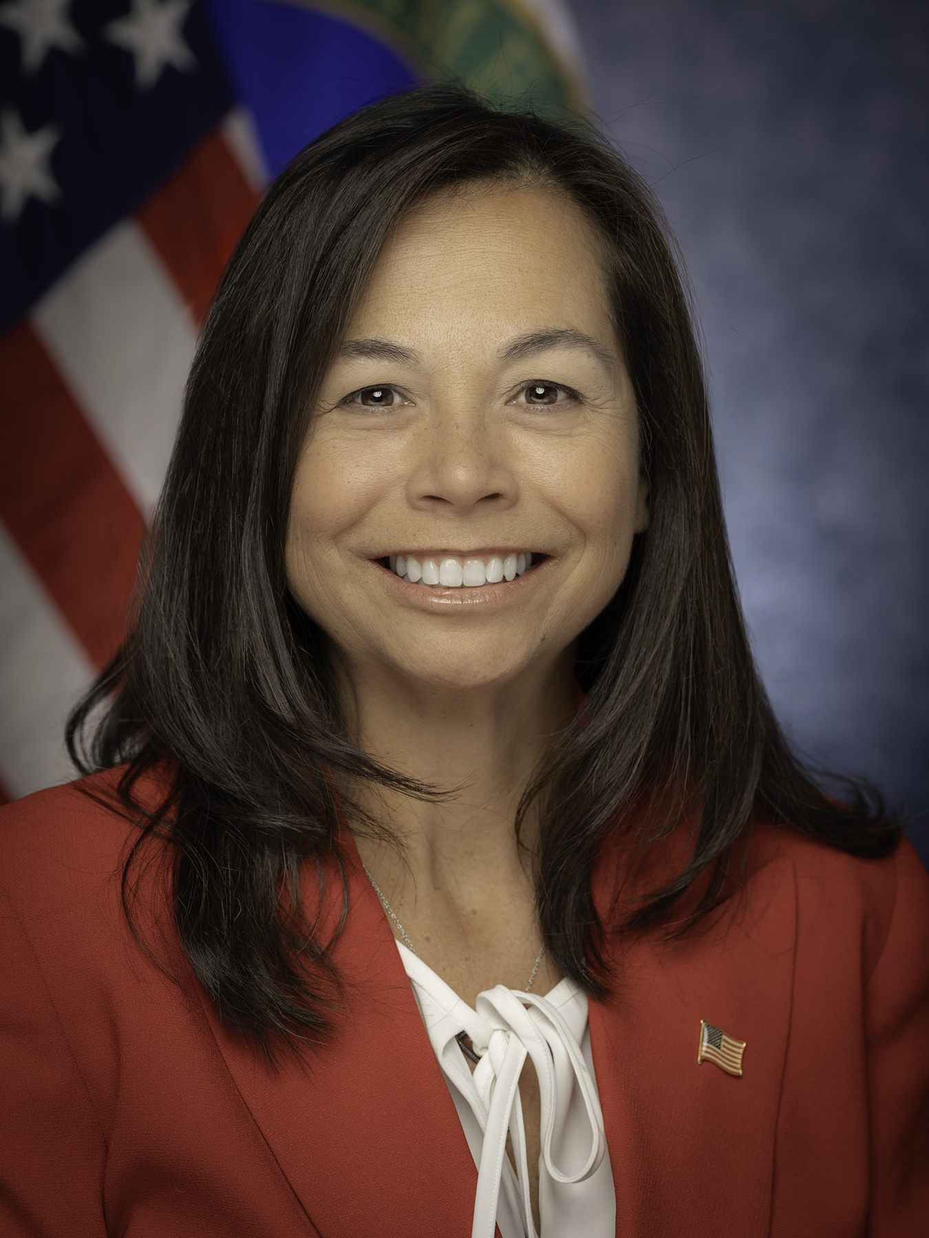 Head and shoulders shot of Catherine Jereza with the American flag in the background.