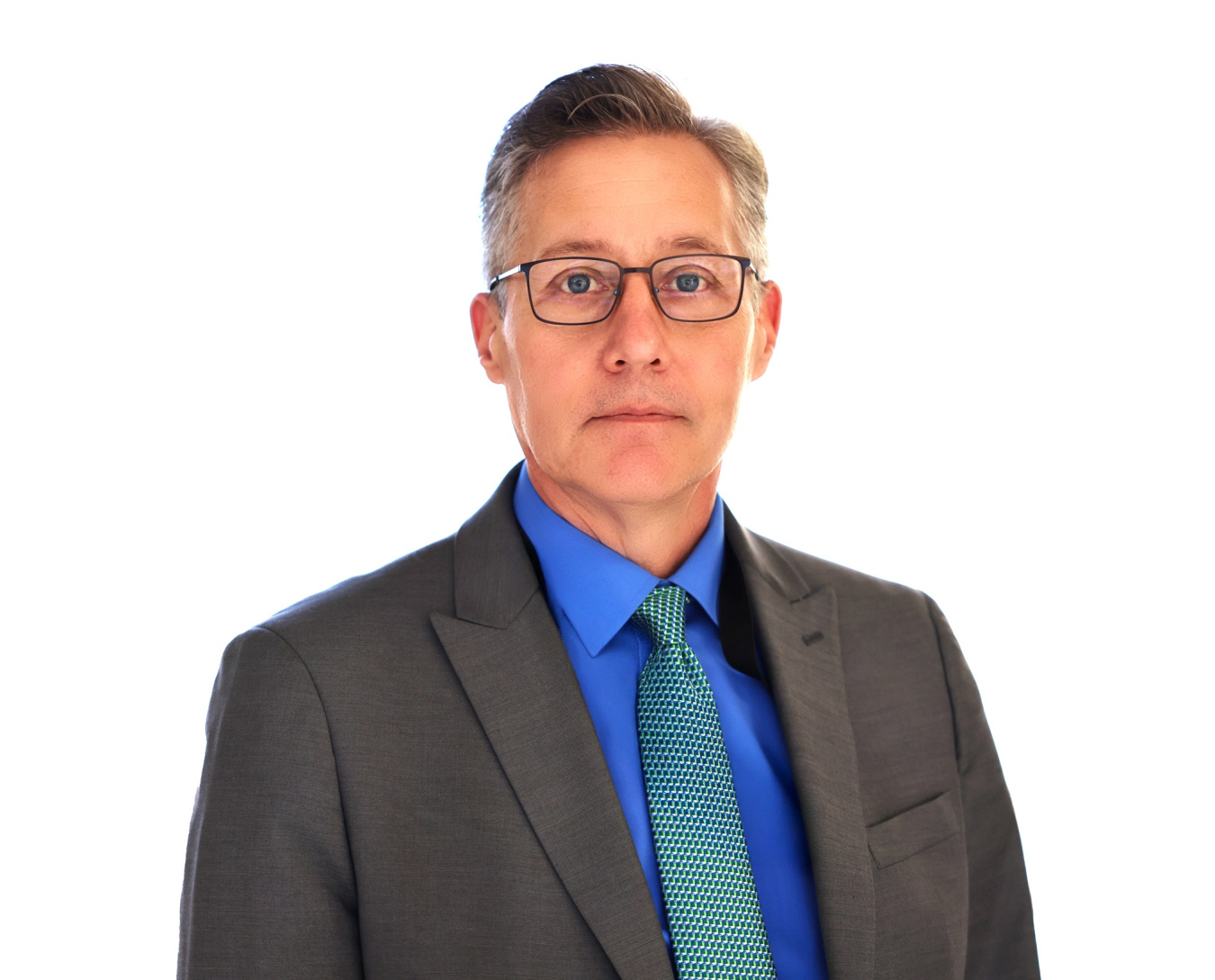 Portrait of a man in a grey suit with a blue shirt and tie, and glasses