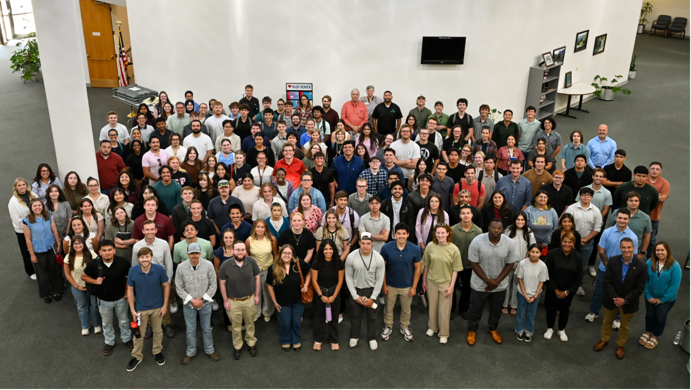 A large group of people inside a building smiling for a group picture