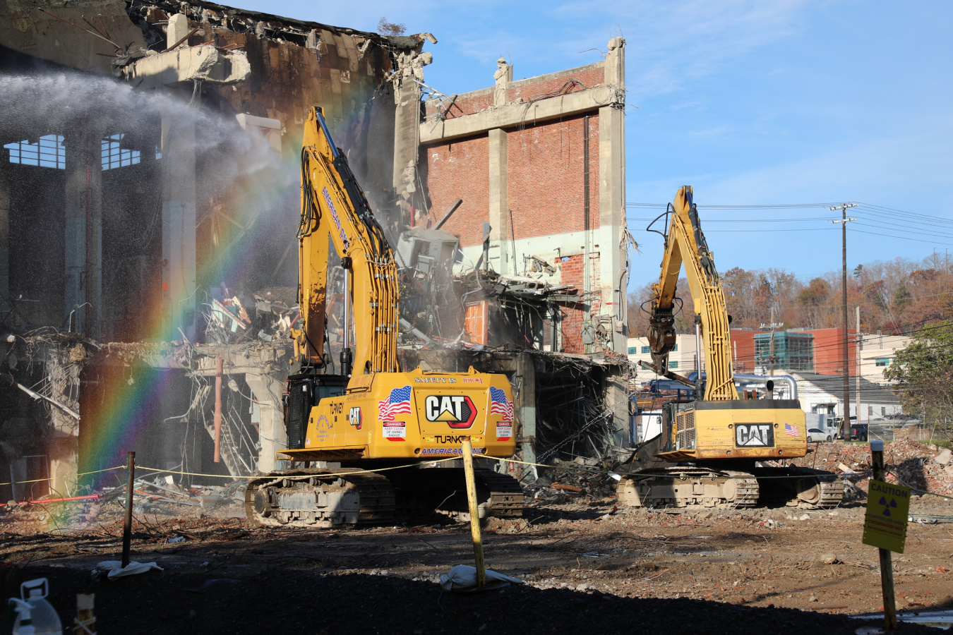 Two construction vehicles demolishing a building at the Oak Ridge site