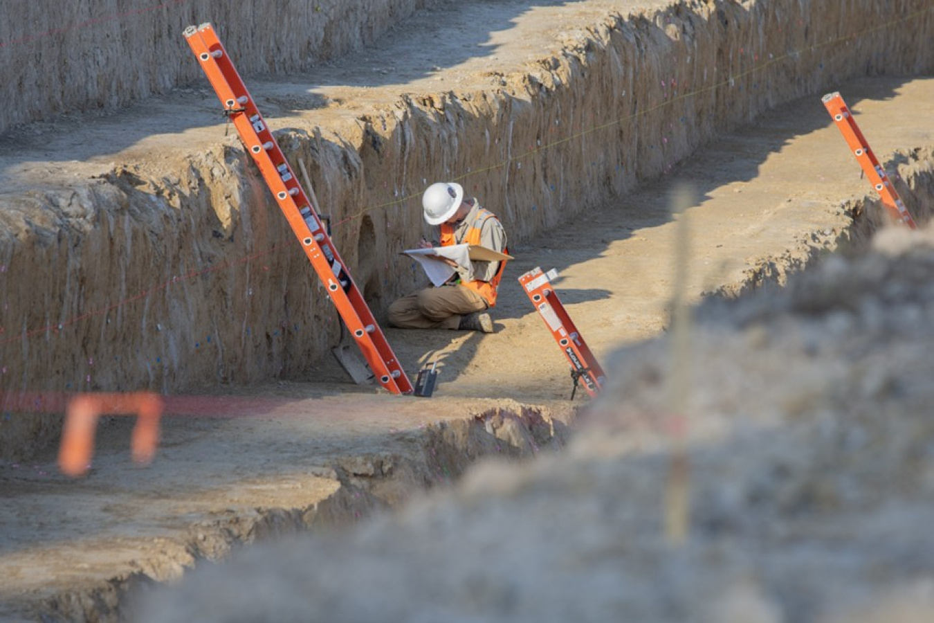 An employee wearing protective gear conducting work inside a trench at the Paducah Site