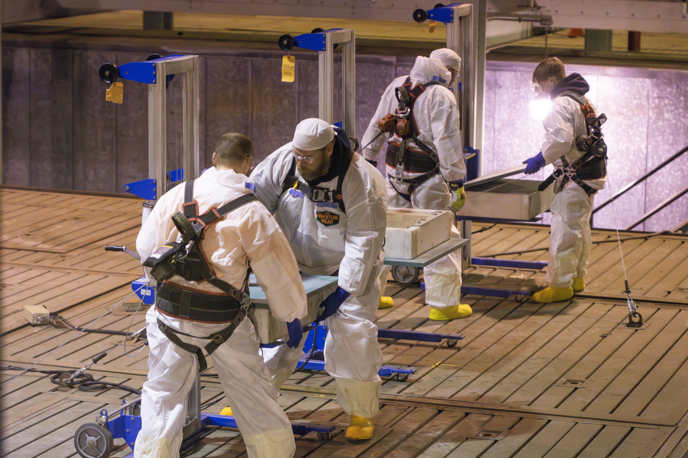 Employees in protective gear using scan detectors at the Oak Ridge Site