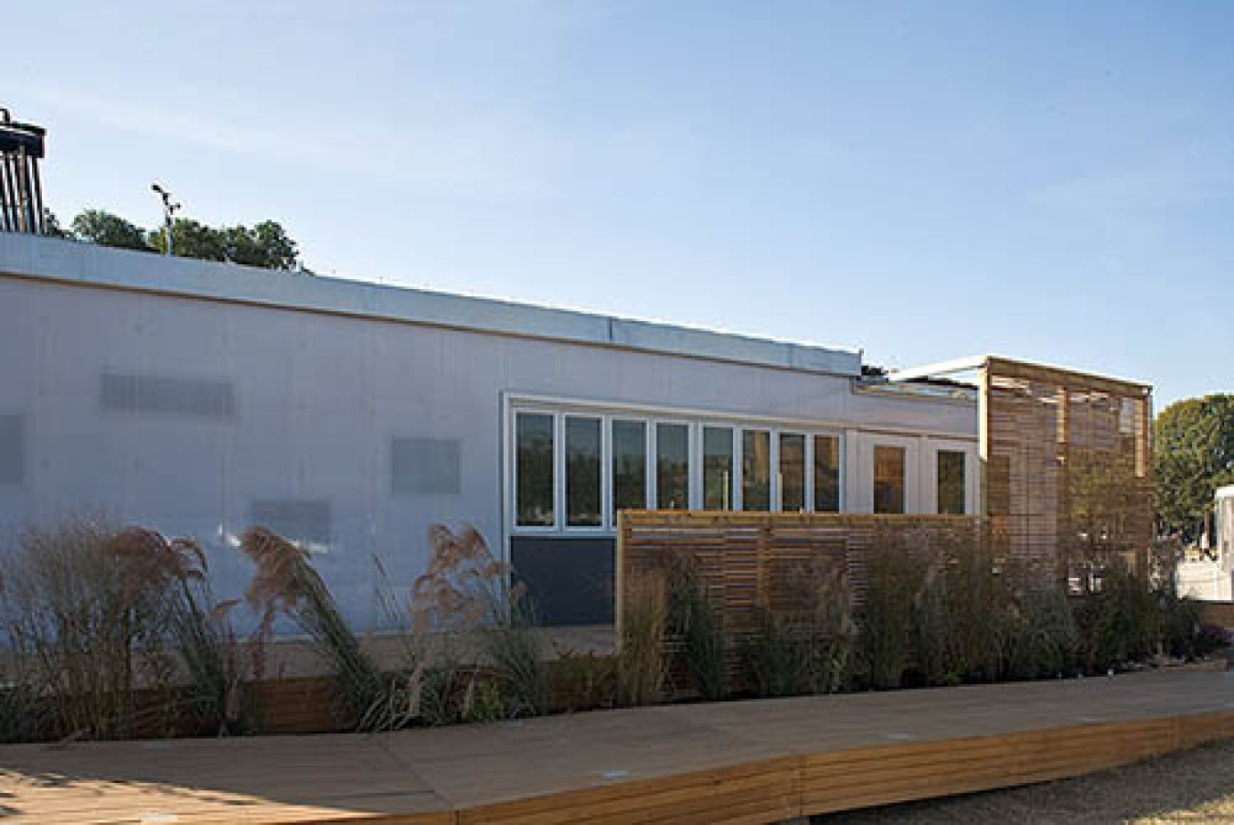 Exterior of the Kansas team's Build Challenge house, showing a plain facade with several window panels clustered together on one end.