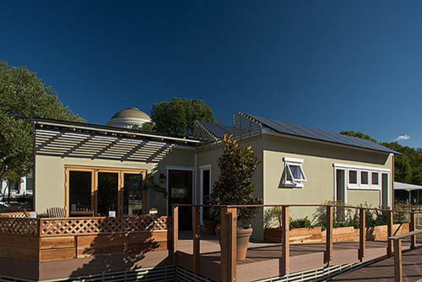 Exterior of the Santa Clara team's Build Challenge house, showing two different sections, windows along the front, and a railed walkway in front.
