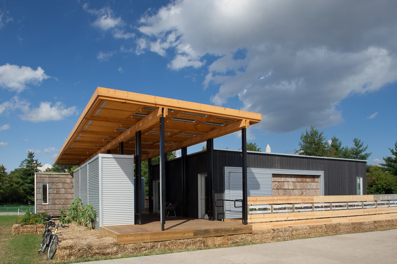 Exterior of the Appalachian team house, showing and straight overhang roof over an open front entrance area, and a sunny sky above.