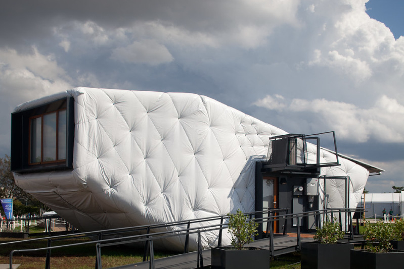 Exterior of the Southern California Institute team's Build Challenge house, showing a futuristic-looking structure with a quilted-looking oblong shape that has a square-shaped windowed panel on one side.