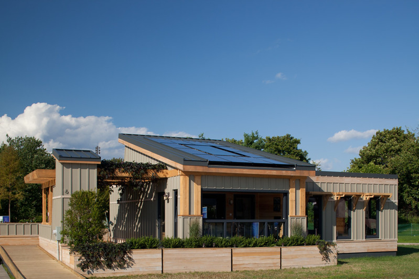 Exterior of the Tidewater team's Build Challenge house, showing solar panels on the center section of the roof and a columned front.