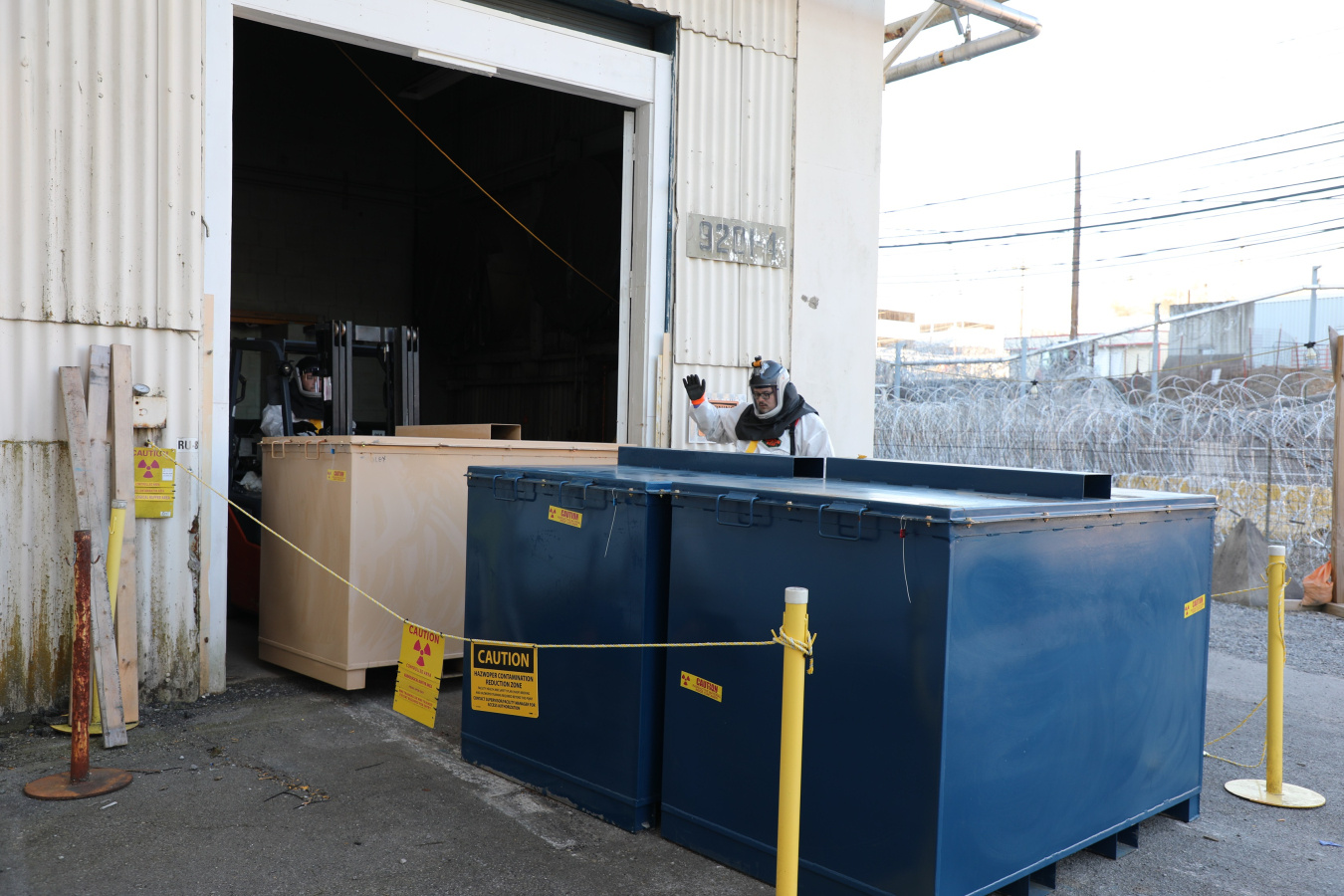 Large blue and tan bins outside a facility building at the Oak Ridge Site