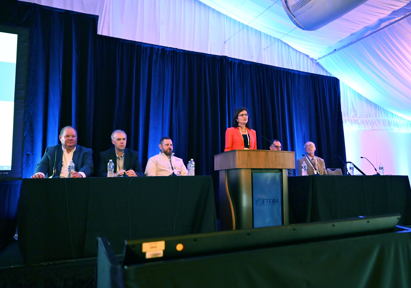 A group of professional on stage conducting a panel at a conference
