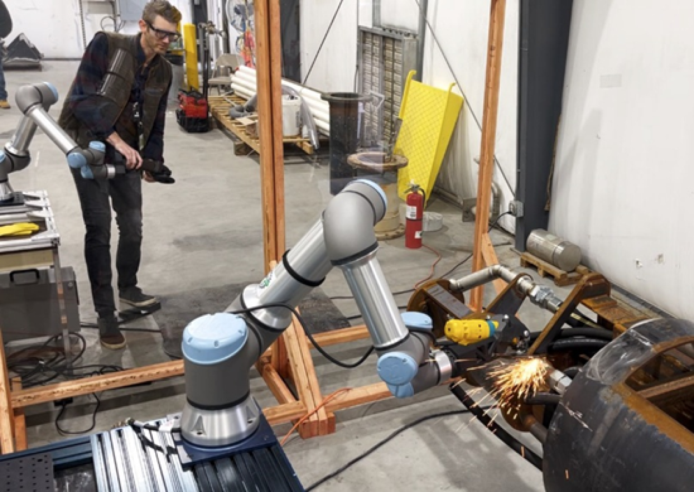 A person operating a macnical arm robot. 