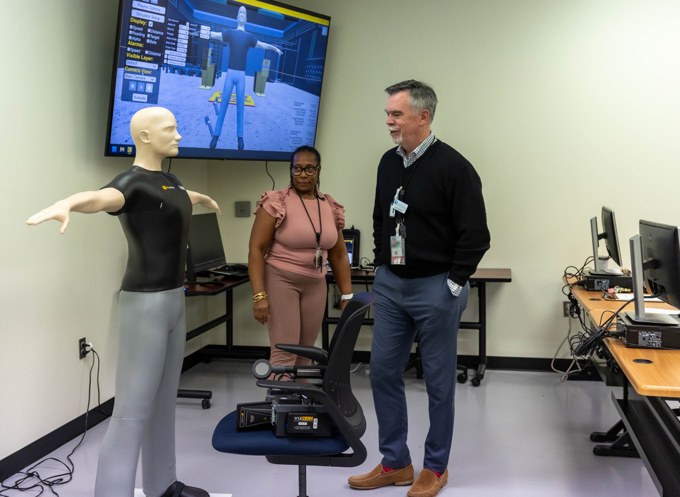 Two employees taking part in safety training with a training doll
