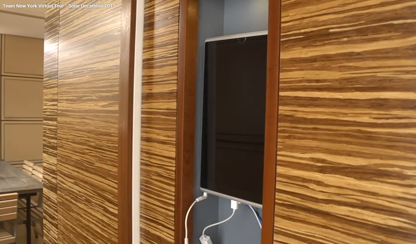 The inside of Team New York's 2011 Build Challenge house, showing a wall-mounted touchscreen for an internet-connected home control system.