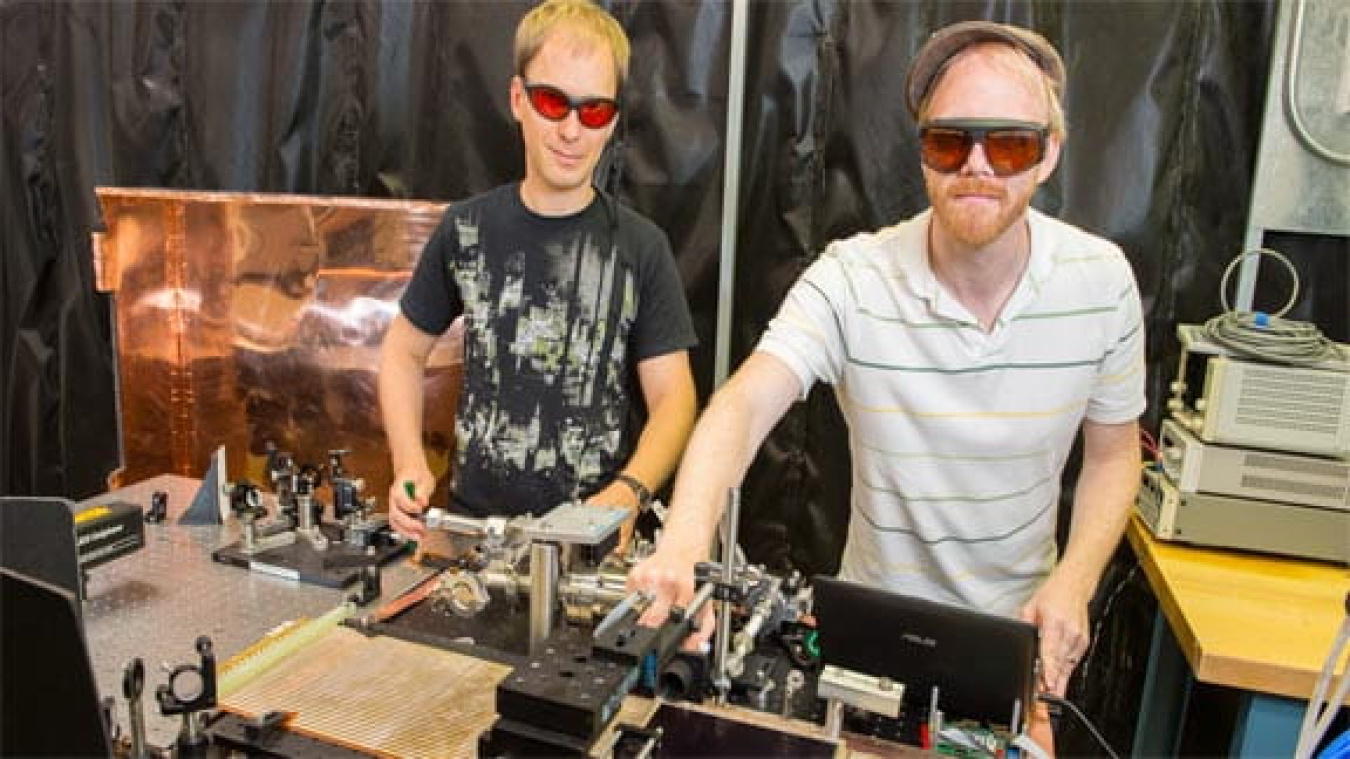 Andrey Elagin (left), postdoctoral scholar at the Enrico Fermi Institute at the University of Chicago, and Matthew Wetstein, the Grainger Postdoctoral Fellow at the Enrico Fermi Institute at the University of Chicago, adjust the optics in the Large Area Picosecond Photodetector testing facility.